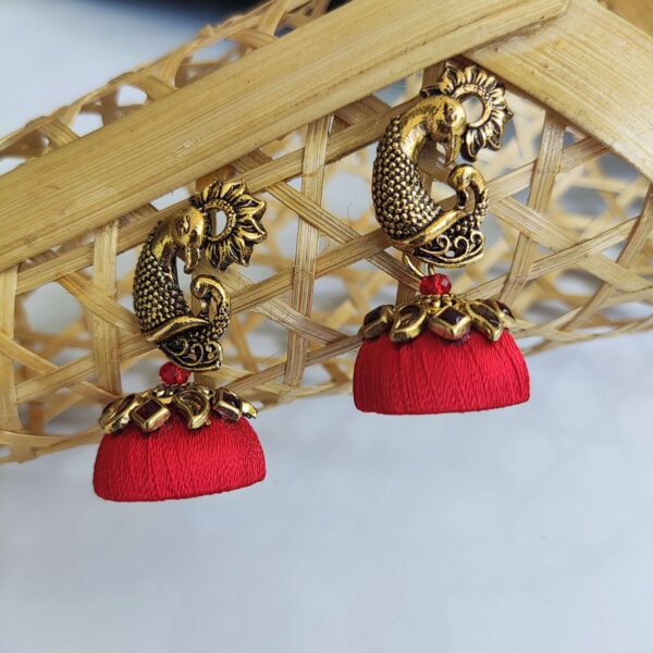 Red jhumka set with kundan embellishments and peacock top